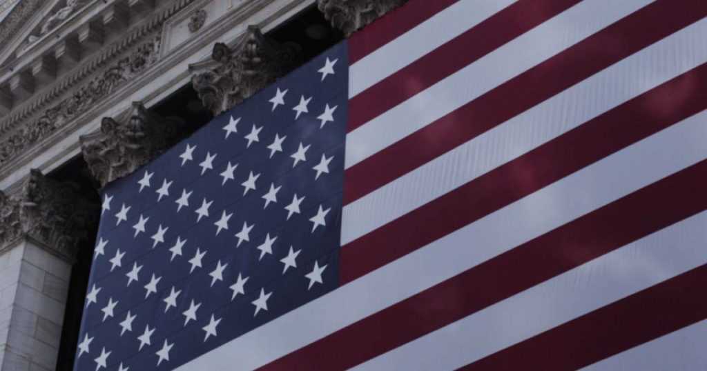 The American Flag displayed against an old building.
