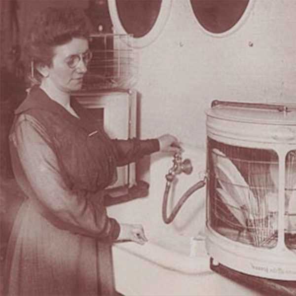 An old photograph of a woman operating the first automatic dishwasher, which was invented by a woman.